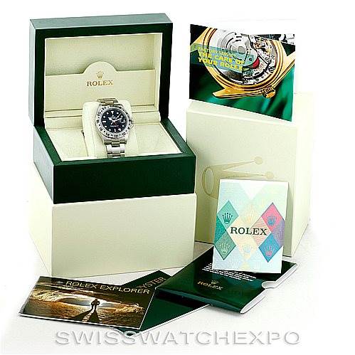 The image displays a Rolex Explorer 16570 Men's Stainless Steel Black Dial 16570 Men's Stainless Steel Black Dial watch in its green and white box, along with booklets, brochures, and warranty cards.