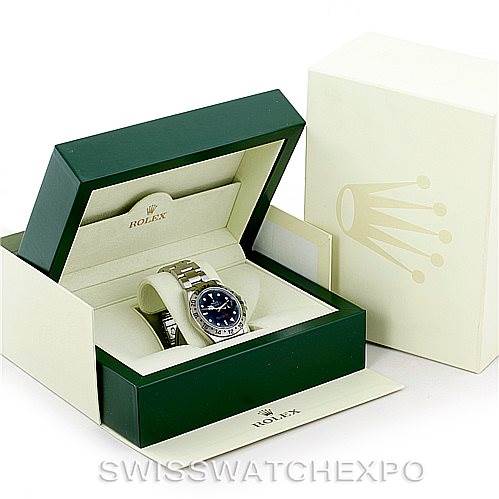 The Rolex Explorer 16570 Men's Stainless Steel Black Dial 16570 Men's Stainless Steel Black Dial watch is displayed inside its open green and white presentation box, with the outer box adjacent.