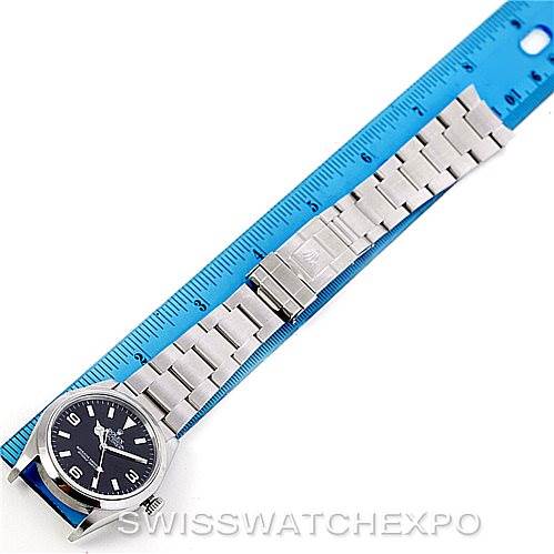 The image shows a Rolex Explorer 114270 Men's Stainless Steel Black Dial 114270 Men's Stainless Steel Black Dial watch in a top-down view, featuring its face, bezel, and full bracelet alongside a ruler for scale.