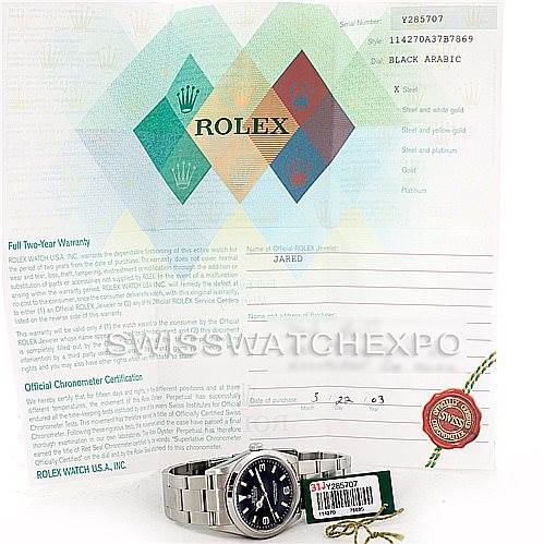 The image shows a Rolex Explorer 114270 Men's Stainless Steel Black Dial 114270 Men's Stainless Steel Black Dial watch, accompanied by its warranty papers and a tag, shot from a front angle.