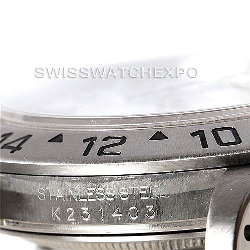 The image shows a close-up of a Rolex Explorer 16570 Men
s Stainless Steel White Dial 16570 Men
s Stainless Steel White Dial watch case, highlighting the bezel with numerals and the engraved serial number.