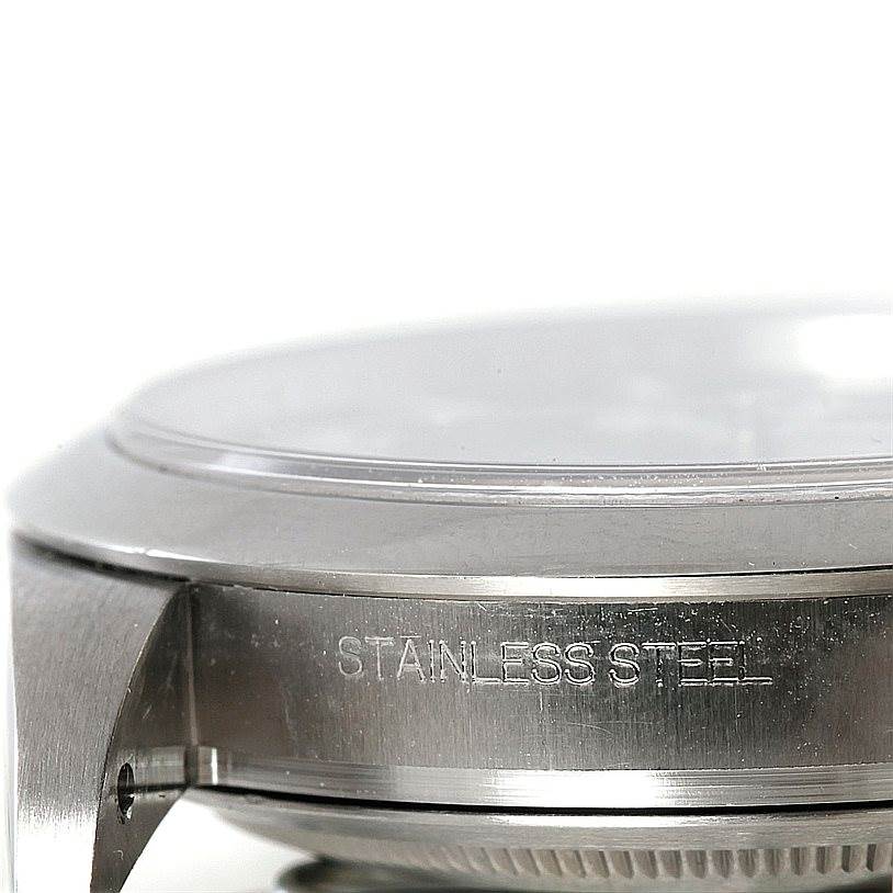 This image shows a side angle of the case and bezel of a Rolex Explorer 214270 Men's Stainless Steel Black Dial 214270 Men's Stainless Steel Black Dial model watch, highlighting the "stainless steel" engraving.