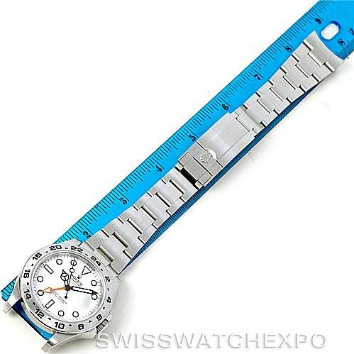 This overhead image of a Rolex Explorer 216570 Men
s Stainless Steel White Dial 216570 Men
s Stainless Steel White Dial watch shows the face, bezel, bracelet, and clasp aligned with a blue ruler for measurement.