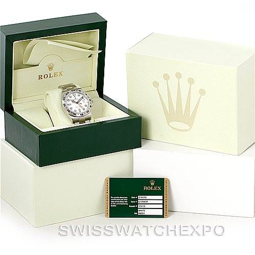 The image features a Rolex Explorer 216570 Men
s Stainless Steel White Dial 216570 Men
s Stainless Steel White Dial watch displayed at an angle in an open box, alongside the outer box and a warranty card.