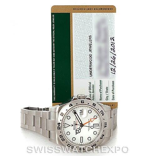 The image shows a Rolex Explorer 216570 Men
s Stainless Steel White Dial 216570 Men
s Stainless Steel White Dial watch at a front angle, alongside its warranty card positioned behind it.