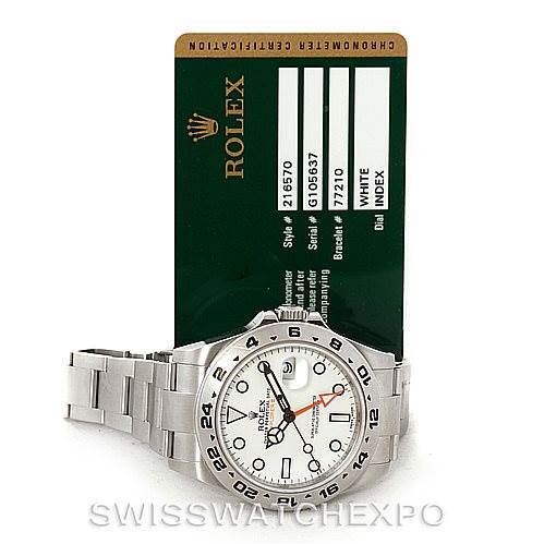 This image shows a Rolex Explorer 216570 Men
s Stainless Steel White Dial 216570 Men
s Stainless Steel White Dial watch placed in front of a Rolex certification card with a partial side view of the bracelet.