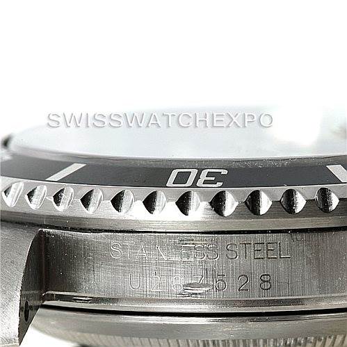 The image shows a close-up, side angle of the Rolex Explorer 16570 Men
s Stainless Steel White Dial 16570 Men
s Stainless Steel White Dial watch’s bezel and part of the case, highlighting "STAINLESS STEEL."