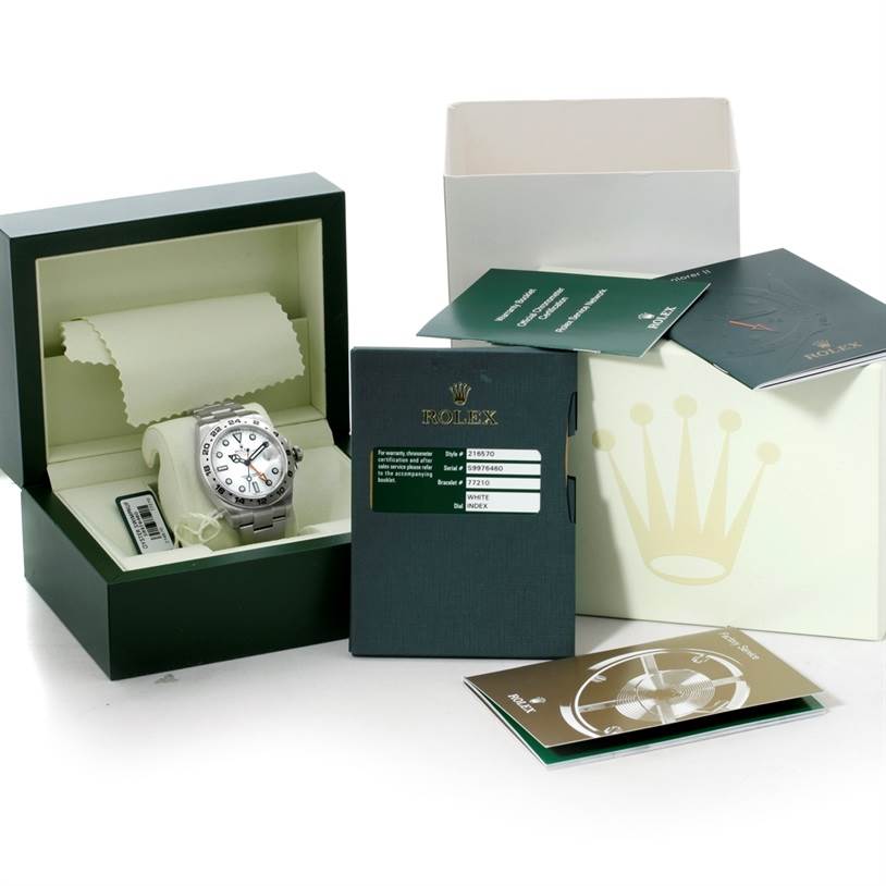 The Rolex Explorer 216570 Men's Stainless Steel White Dial 216570 Men's Stainless Steel White Dial watch is displayed in its open box, accompanied by documentation and booklets.