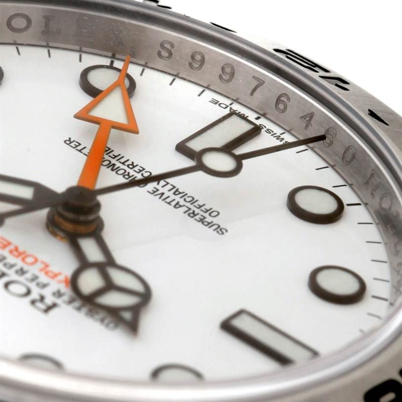 This close-up of the Rolex Explorer 216570 Men's Stainless Steel White Dial 216570 Men's Stainless Steel White Dial watch shows part of the dial, hands, and a portion of the bezel.