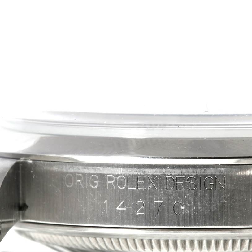The image shows a close-up side view of the Rolex Explorer 14270 Men's Stainless Steel Black Dial 14270 Men's Stainless Steel Black Dial model, focusing on the engraved text and serial number on the case.
