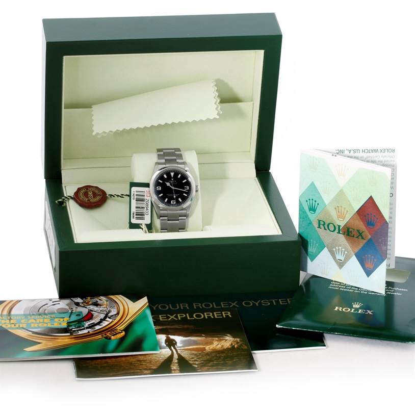 The image shows a Rolex Explorer 114270 Men's Stainless Steel Black Dial 114270 Men's Stainless Steel Black Dial watch in its box with accompanying booklets and tags from a front angle.