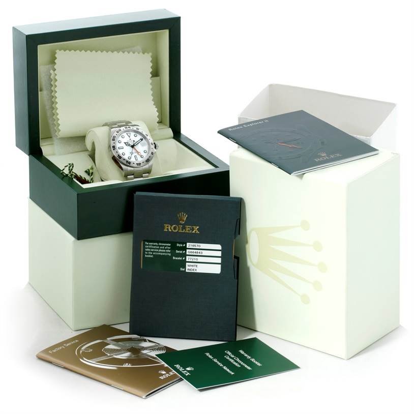 The image shows a Rolex Explorer 216570 Men
s Stainless Steel White Dial 216570 Men
s Stainless Steel White Dial watch in an open box, accompanied by manuals and certification cards.