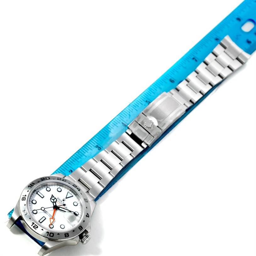 The image shows a Rolex Explorer 216570 Men's Stainless Steel White Dial 216570 Men's Stainless Steel White Dial watch laid flat, showcasing its face, bracelet, and clasp, with a ruler for scale.