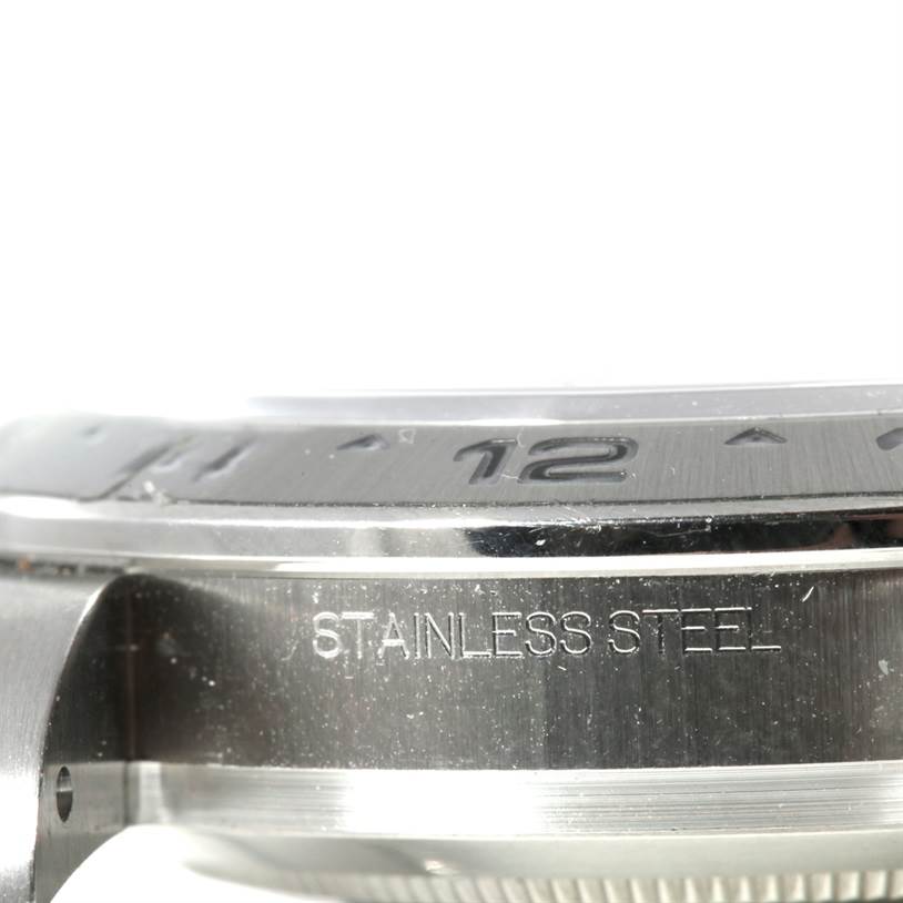 The image shows a close-up side angle of the stainless steel case and bezel of a Rolex Explorer 216570 Men's Stainless Steel White Dial 216570 Men's Stainless Steel White Dial watch.