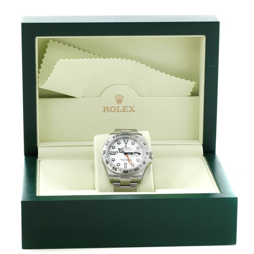 The Rolex Explorer 216570 Men's Stainless Steel White Dial 216570 Men's Stainless Steel White Dial watch is displayed in an open green box, showing its face, bezel, and bracelet, with cleaning cloths above.