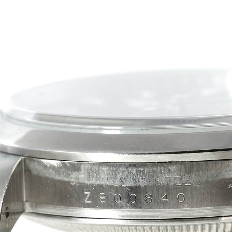 This image shows a side view of a Rolex Explorer watch case, highlighting the serial number engraved on the stainless steel casing.