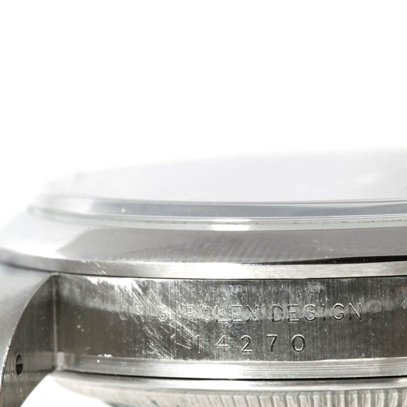 This image shows a close-up of the side of a Rolex Explorer 114270 Men's Stainless Steel Black Dial 114270 Men's Stainless Steel Black Dial watch, highlighting the case and part of the bezel with engraved text.