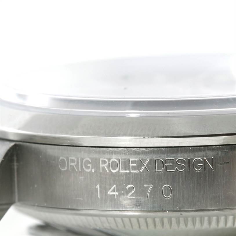 The image shows a close-up side view of a Rolex Explorer 14270 Men's Stainless Steel Black Dial 14270 Men's Stainless Steel Black Dial model case with the engraving "ORIG. ROLEX DESIGN 14270".