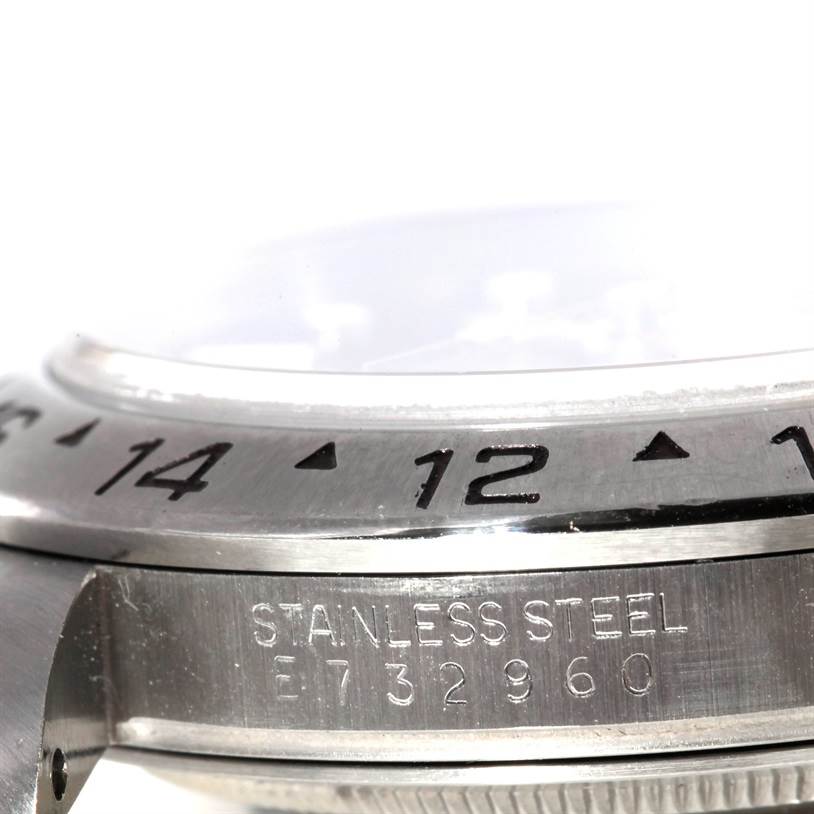 The image shows a close-up angle of the side of a Rolex Explorer 16570 Men's Stainless Steel Black Dial 16570 Men's Stainless Steel Black Dial watch, highlighting the bezel, serial number, and stainless steel marking.