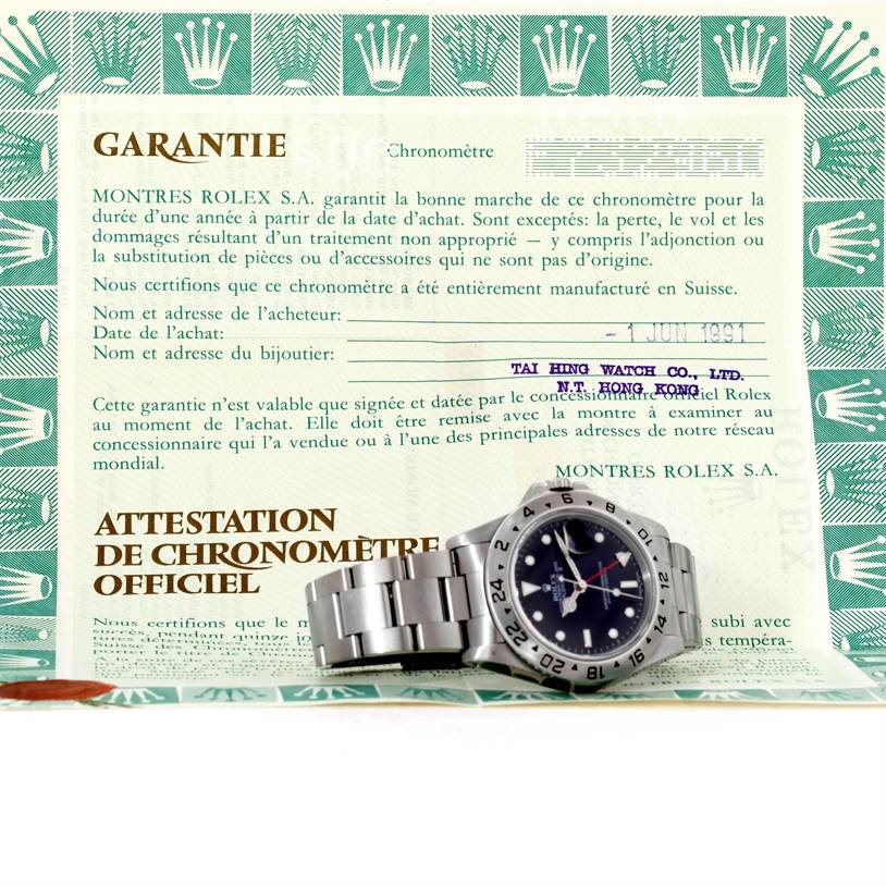 The image shows a Rolex Explorer 16570 Men's Stainless Steel Black Dial 16570 Men's Stainless Steel Black Dial watch laid on its warranty document, displaying the watch face and bracelet.