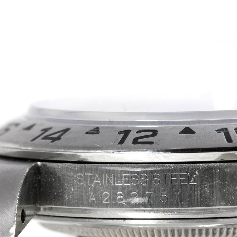 This image shows a close-up of the stainless steel bezel and part of the case with engraved details of a Rolex Explorer 16570 Men's Stainless Steel White Dial 16570 Men's Stainless Steel White Dial watch.