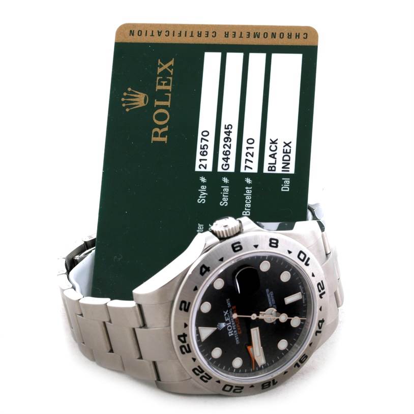 The image shows a Rolex Explorer 216570 Men's Stainless Steel Black Dial 216570 Men's Stainless Steel Black Dial model watch lying on its bracelet with its face and bezel visible, alongside its certification card.