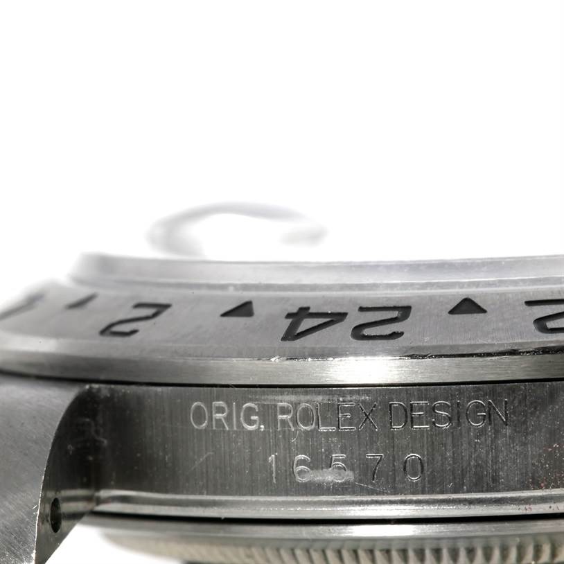 The image shows a close-up of the bezel and case side of the Rolex Explorer 16570 Men's Stainless Steel White Dial 16570 Men's Stainless Steel White Dial watch, highlighting the inscription and markings.