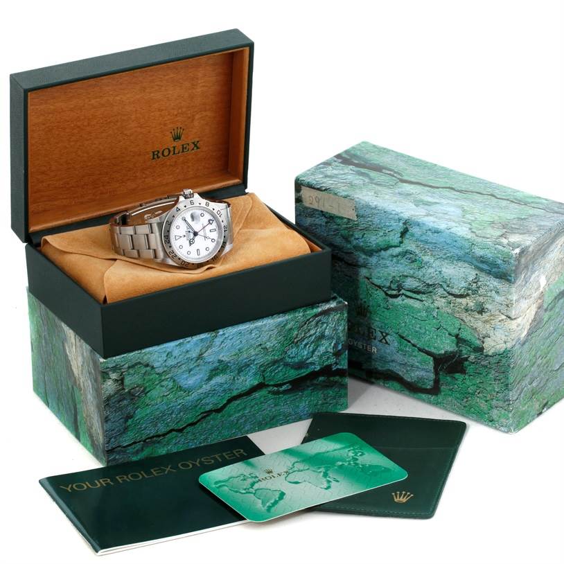 The image shows a Rolex Explorer 16570 Men's Stainless Steel White Dial 16570 Men's Stainless Steel White Dial watch inside its box, with additional accessories including booklets and a warranty card displayed.