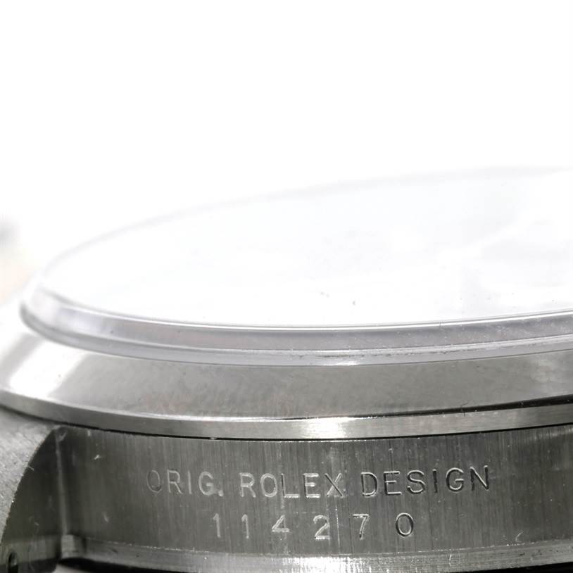 The image shows a close-up of the side of a Rolex Explorer 114270 Men's Stainless Steel Black Dial 114270 Men's Stainless Steel Black Dial watch, highlighting the engraved model number and design markings.