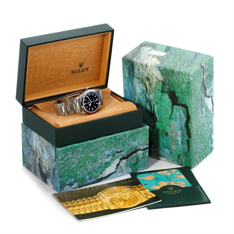The image shows a Rolex Explorer 114270 Men's Stainless Steel Black Dial 114270 Men's Stainless Steel Black Dial watch in an open box with additional brochures and packaging.