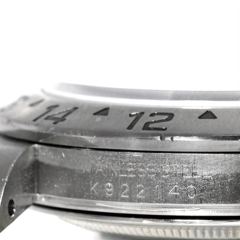 The image shows a close-up of the bezel and part of the case of a Rolex Explorer 16570 Men's Stainless Steel White Dial 16570 Men's Stainless Steel White Dial watch, emphasizing the engraved numbers and markings.