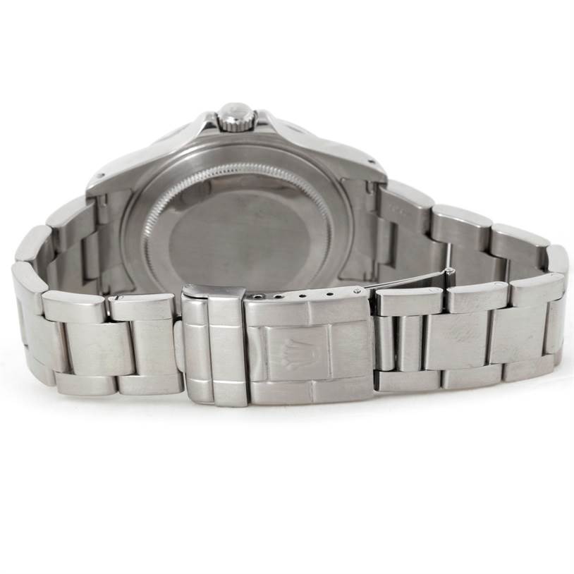 The image shows the backside of a Rolex Explorer 16570 Men's Stainless Steel White Dial 16570 Men's Stainless Steel White Dial watch and its stainless steel bracelet with a visible clasp.