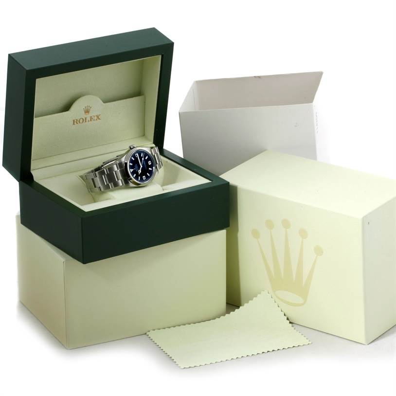 The image shows a Rolex Explorer 114270 Men's Stainless Steel Black Dial 114270 Men's Stainless Steel Black Dial model watch at a slight angle, presented in an open green and cream box with inner and outer packaging.