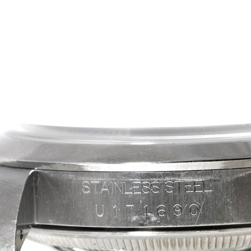 The image shows a close-up of the side of the case back of a Rolex Explorer 14270 Men's Stainless Steel Black Dial 14270 Men's Stainless Steel Black Dial watch, displaying the serial number and "STAINLESS STEEL" text.