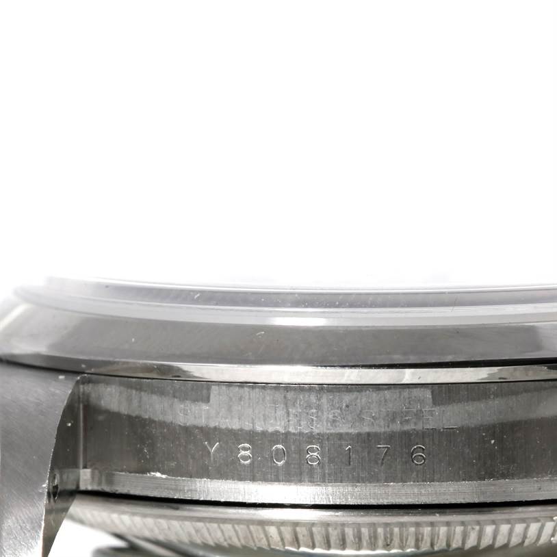The image shows a close-up of the side of a Rolex Explorer 114270 Men's Stainless Steel Black Dial 114270 Men's Stainless Steel Black Dial watch, featuring the serial number on the case.