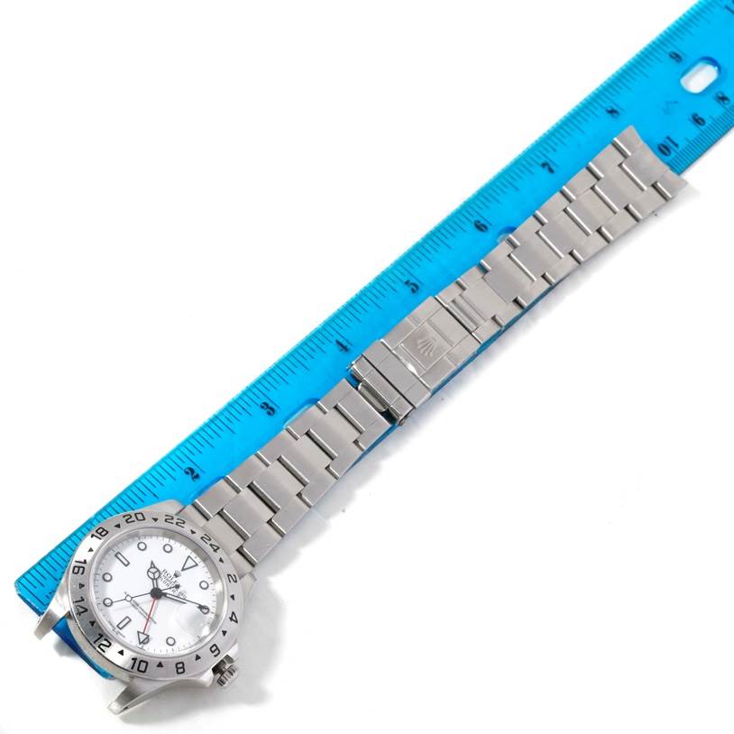 The image shows a Rolex Explorer 16570 Men's Stainless Steel White Dial 16570 Men's Stainless Steel White Dial watch lying flat, measured alongside a blue ruler, highlighting the watch face and metal bracelet.