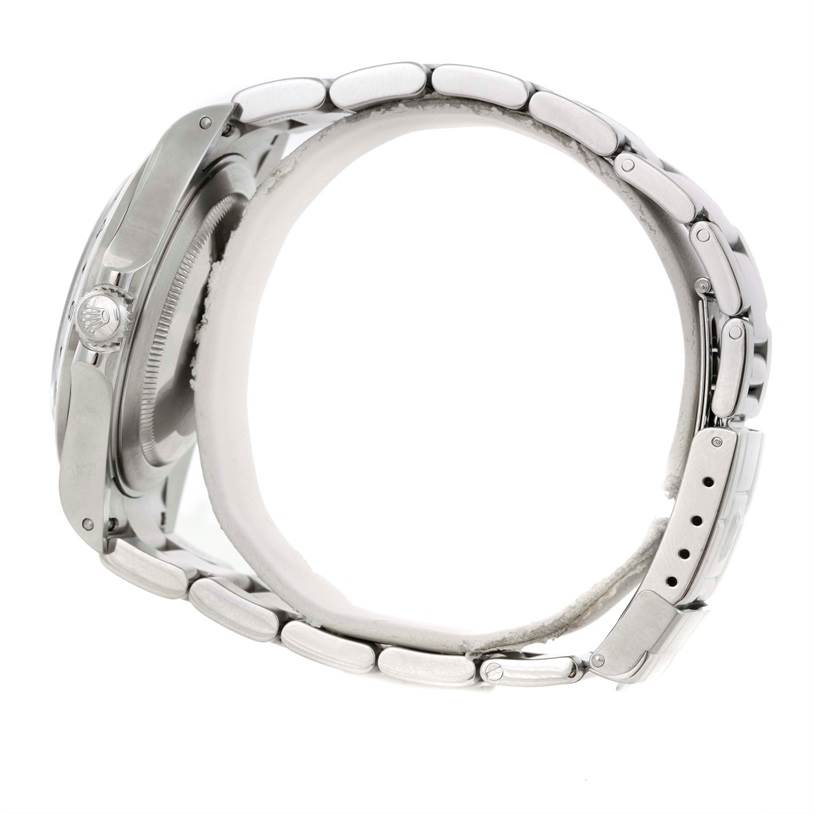 This side angle view of the Rolex Explorer 16570 Men's Stainless Steel White Dial 16570 Men's Stainless Steel White Dial shows the watch case, crown, and metal bracelet.