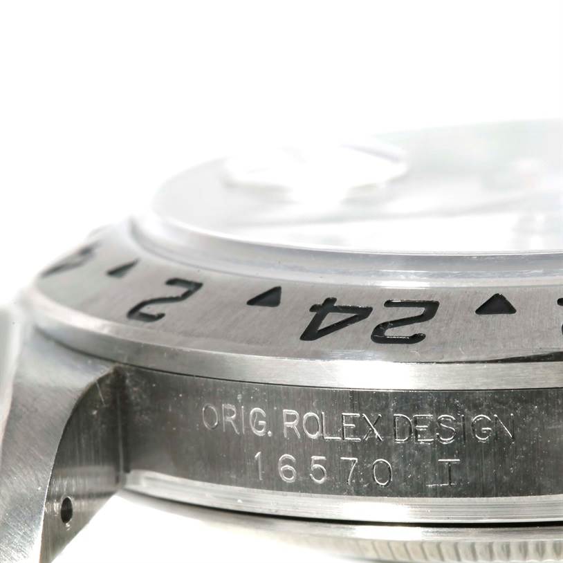 This close-up image shows the side and bezel of the Rolex Explorer 16570 Men's Stainless Steel White Dial 16570 Men's Stainless Steel White Dial, highlighting the model number 16570 and "ORIG. ROLEX DESIGN" engraving.