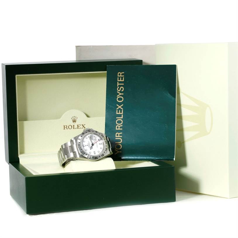 The Rolex Explorer 16570 Men's Stainless Steel White Dial 16570 Men's Stainless Steel White Dial watch is shown from a front angle, displayed in its open box with accompanying booklets and packaging in the background.