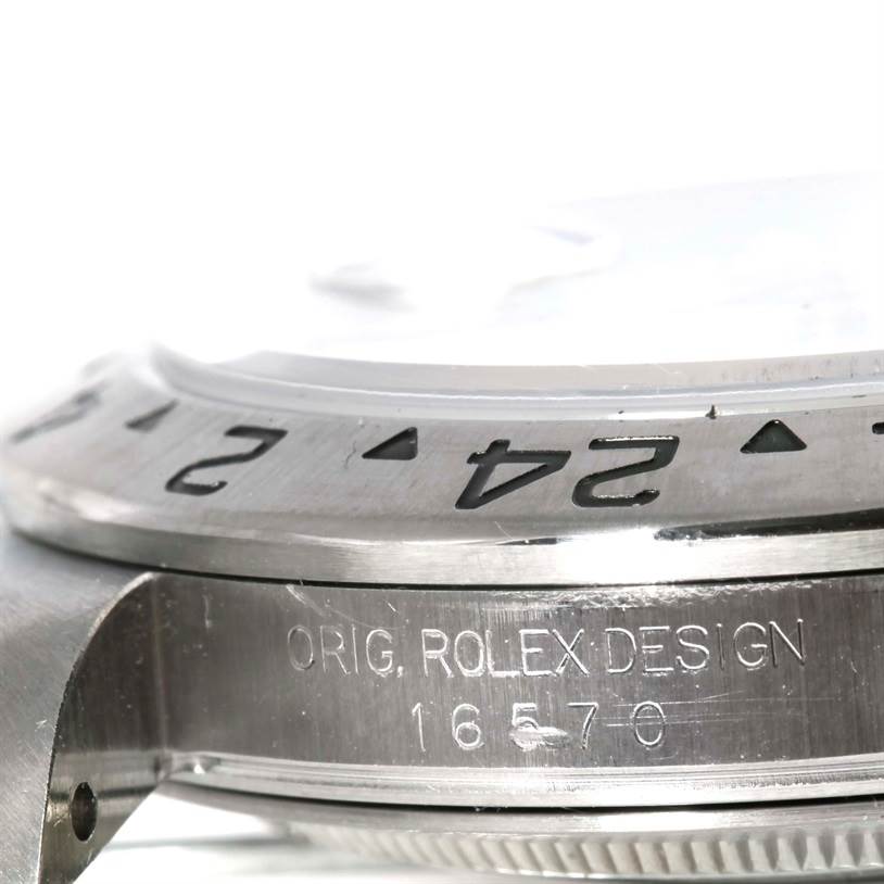 This close-up image shows the edge of the bezel and case side of the Rolex Explorer 16570 Men's Stainless Steel White Dial 16570 Men's Stainless Steel White Dial watch, highlighting its design and engravings.