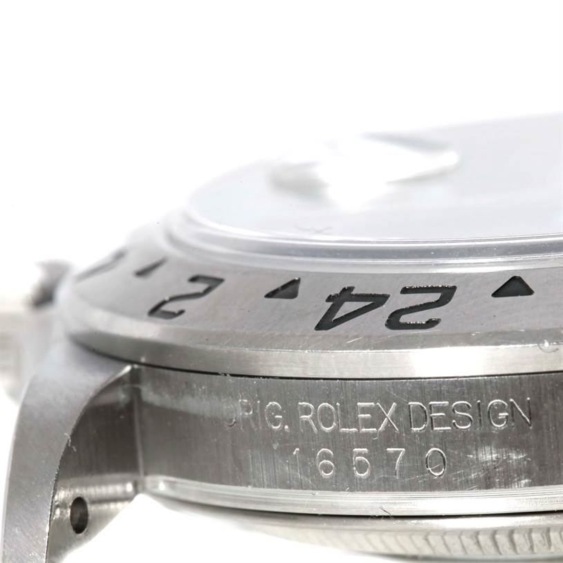 Close-up of a Rolex Explorer 16570 Men's Stainless Steel Black Dial 16570 Men's Stainless Steel Black Dial watch showing the bezel and the "ORIG. ROLEX DESIGN 16570" engraving on the case side.
