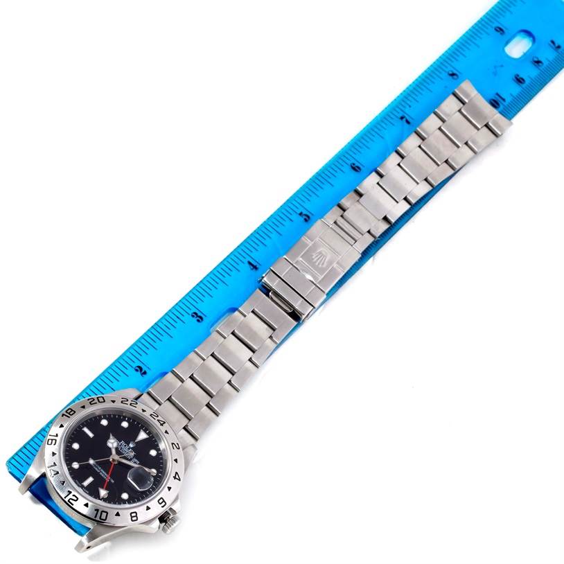 The Rolex Explorer 16570 Men's Stainless Steel Black Dial 16570 Men's Stainless Steel Black Dial watch is laid flat next to a ruler, showing the face, bezel, and full length of the bracelet.
