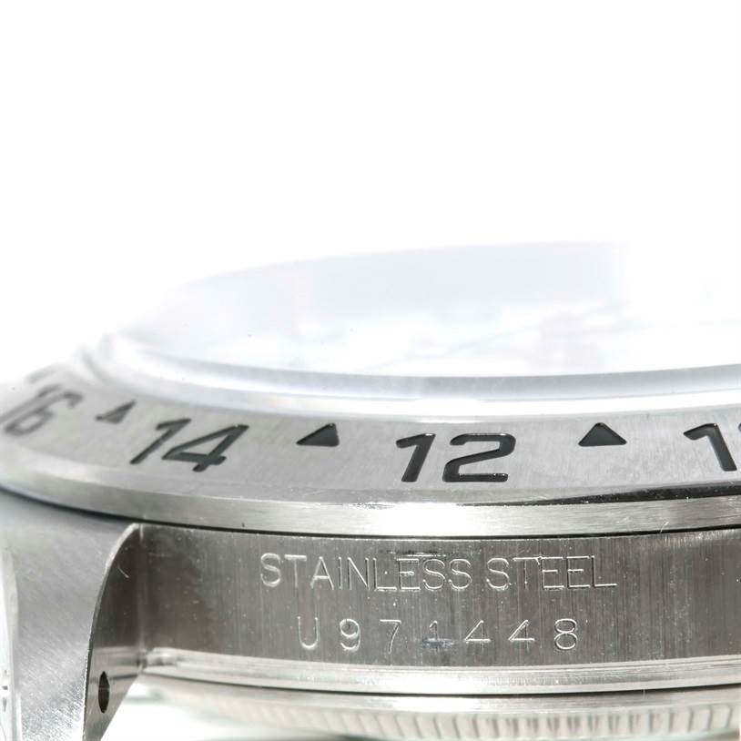 The image shows a close-up of the side view of a Rolex Explorer 16570 Men's Stainless Steel White Dial 16570 Men's Stainless Steel White Dial watch, highlighting the bezel and part of the casing with serial engravings.
