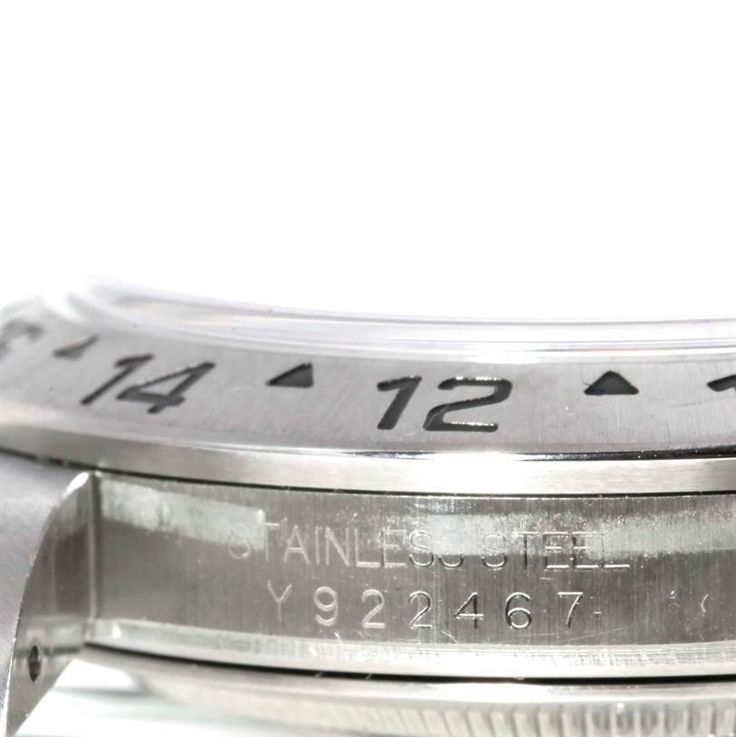 The image shows a close-up side view of a Rolex Explorer 16570 Men's Stainless Steel White Dial 16570 Men's Stainless Steel White Dial watch, displaying the bezel numbers and part of the case with engravings.