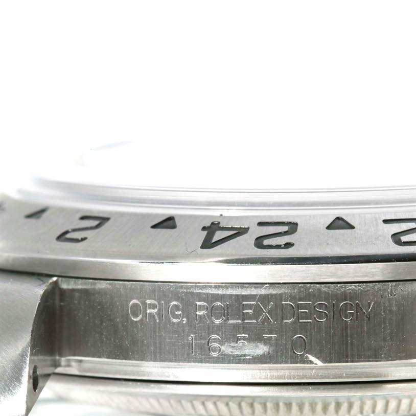 This close-up image shows the side of the bezel and part of the case of a Rolex Explorer 16570 Men
s Stainless Steel White Dial 16570 Men
s Stainless Steel White Dial watch, with visible engravings.