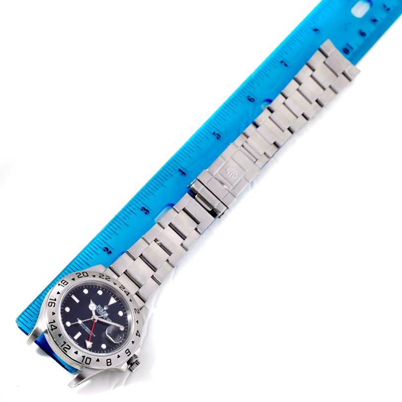 The image shows a Rolex Explorer 16570 Men's Stainless Steel Black Dial 16570 Men's Stainless Steel Black Dial watch laid flat next to a ruler, highlighting the watch face, bezel, and bracelet.