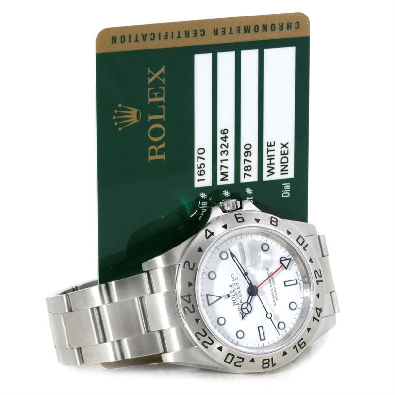 The image shows a Rolex Explorer 16570 Men's Stainless Steel White Dial 16570 Men's Stainless Steel White Dial watch laid on its side against a green Rolex authenticity card.