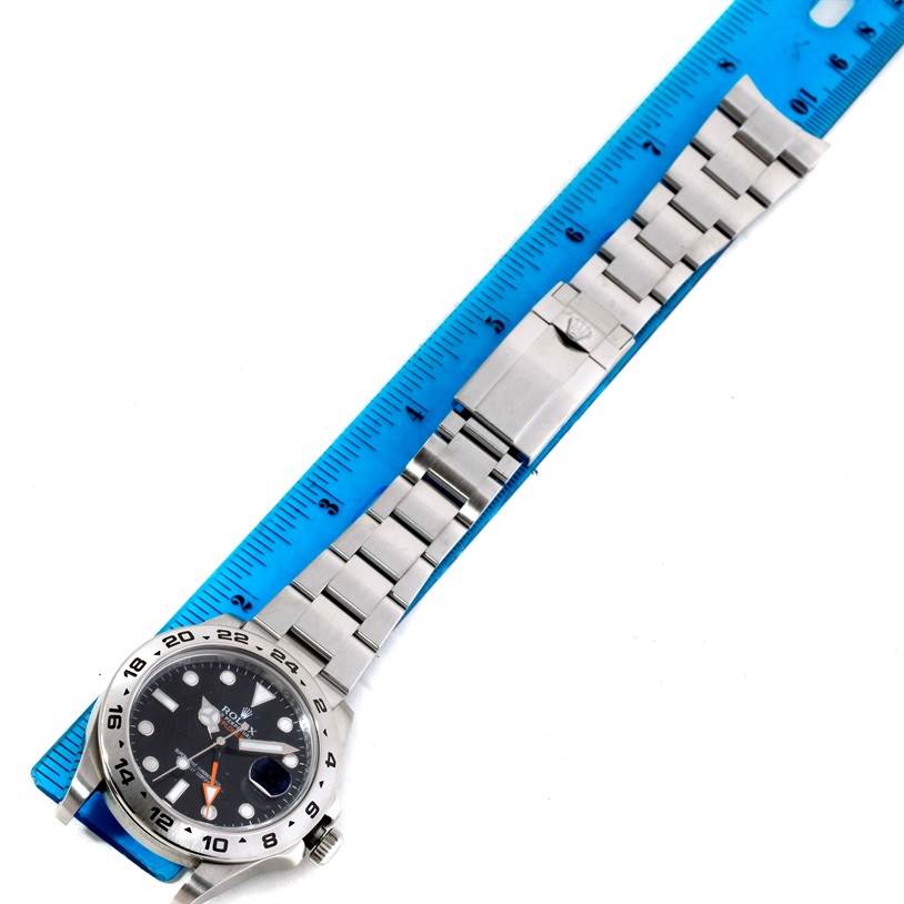 The image shows a Rolex Explorer 216570 Men's Stainless Steel Black Dial 216570 Men's Stainless Steel Black Dial watch laid flat with a ruler, displaying the face and metal bracelet.