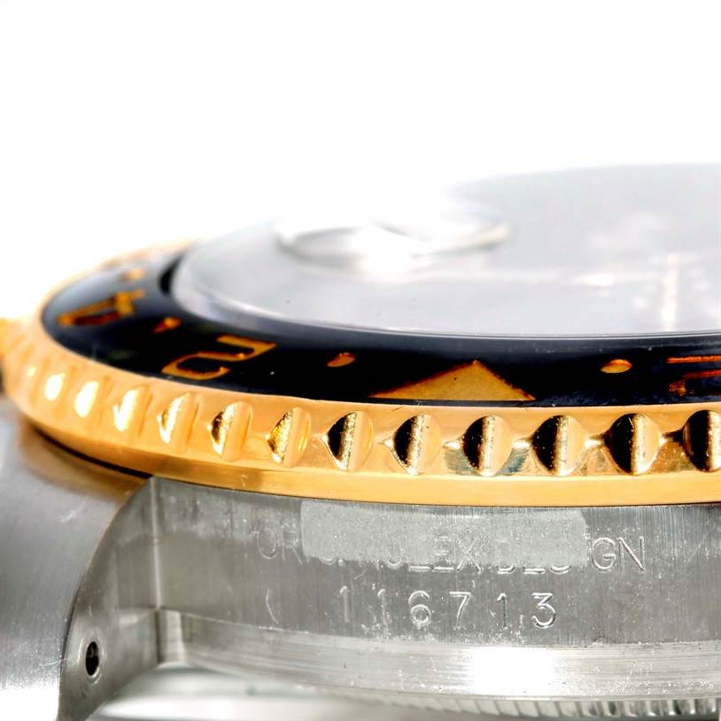 The image shows a close-up side view of a Rolex GMT-Master 116713 Men's Stainless Steel Black Dial 116713 Men's Stainless Steel Black Dial watch, highlighting its bezel and part of the case.