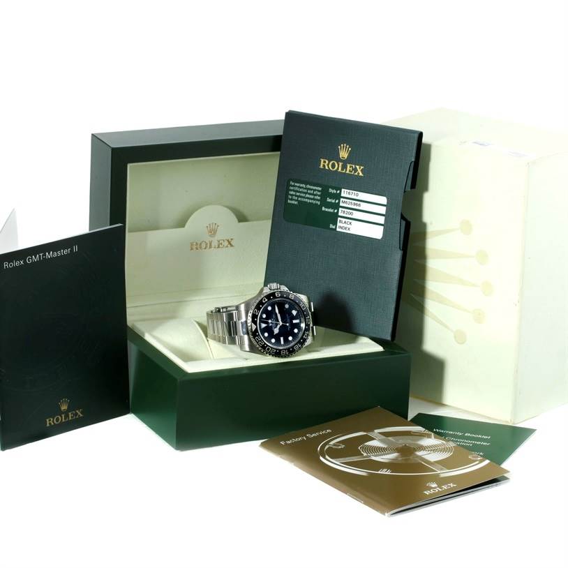 The GMT-Master model Rolex watch is shown at an angle, placed in its open box with accompanying instruction manuals and warranty card.